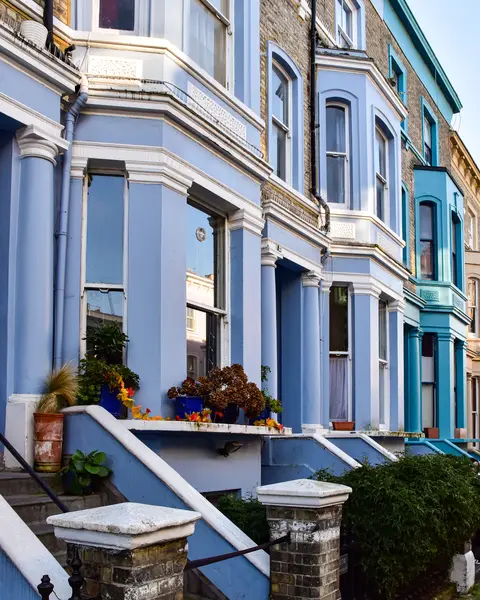 Colourful Victorian terraced houses with bay windows on a London street