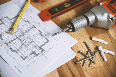 Architectural floor plan on a desk with a tape measure